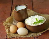 rustic products cottage cheese, milk and eggs on a wooden table