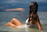 Beautiful brunette in the water at sunset