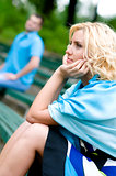 Young woman and man sitting on a bench in park