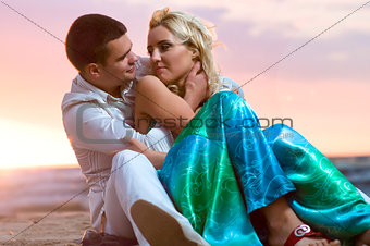 Young couple in love near the sea at sunset