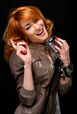 Portrait of a beautiful redhead singer over black background