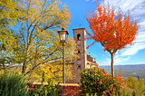 Old belfry among autumnal trees in Piedmont, Italy.