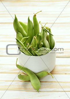pods of green peas on a wooden table