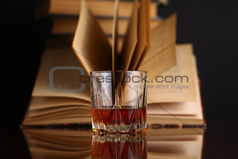 Glass of whiskey and books