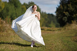 Happy caucasian bride walking field.