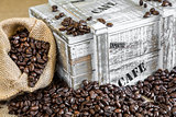 burlap bag filled with coffee beans beside old wooden box