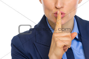 Closeup on business woman showing shh gesture