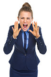 Angry business woman shouting through megaphone shaped hands