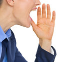 Closeup on business woman shouting through megaphone shaped hand