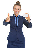 Portrait of smiling business woman showing business card and thu