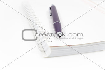 Spiral notebook with pen isolated on white background