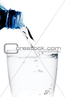 pouring a glass with water trough little blue bottle