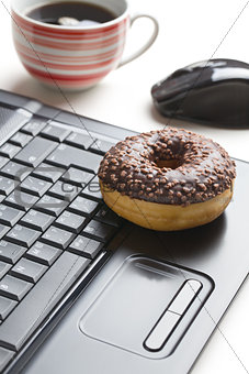 break in the office . doughnut on laptop keyboard