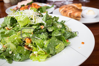 Closed up caesar salad served on wooden table