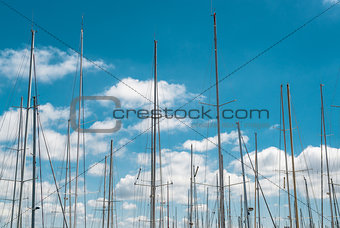 Ship masts over blue sky background