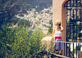 Beautiful young woman and view of Positano, Italy
