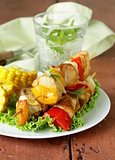 chicken kebabs with vegetables on wooden skewers