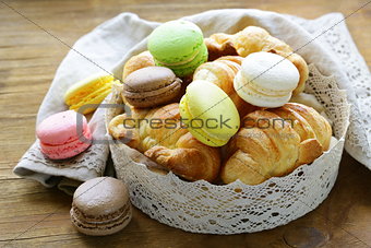traditional French pastries croissants and macaroons in a lace basket