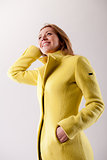 real woman in yellow coat smiling