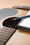 Notebook and pencil on guitar