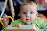 Close-up portrait of cute baby in play gym toy