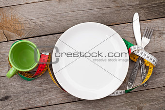 Plate with measure tape, cup, knife and fork. Diet food