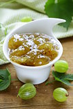 Green gooseberry jam on a wooden table