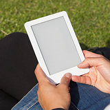 Woman reading ebook on the grass