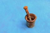 antique rusty iron mortar with pestle on blue background