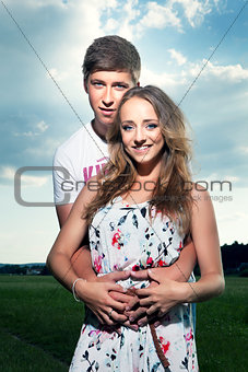Young couple in nature on summer, they looking into the camera
