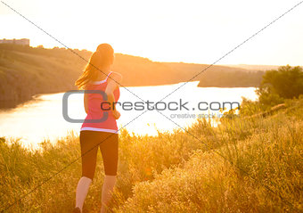 Young Beautiful Woman Running on the Mountain Trail in the Morning