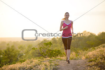Young Beautiful Woman Running on Mountain Trail in the Morning