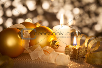 Golden Christmas background with candles, baubles and ribbons 