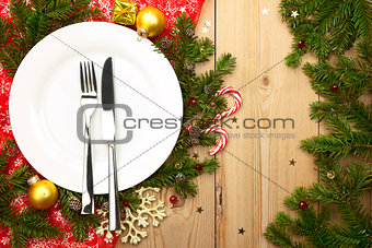 Christmas Dinner - white plate with cutlery on wooden background