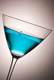 glass with blue cocktail tilted
