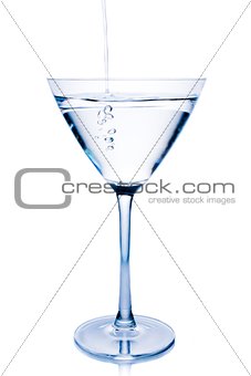 filling a  white cocktail in a glass with blue reflections 