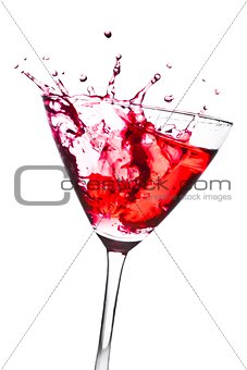 red cocktail with splashing in the tilted glass
