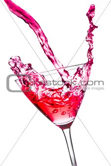 red cocktail with splashing in the tilted glass