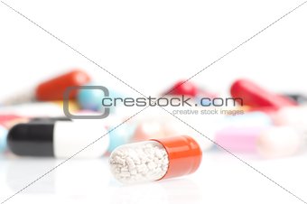 one medical pill in front of a lot of medical pills in laboratory
