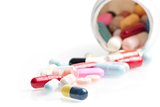 colored pills in laboratory near white container