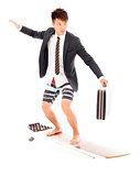 business man holding a briefcase and standing surfing board