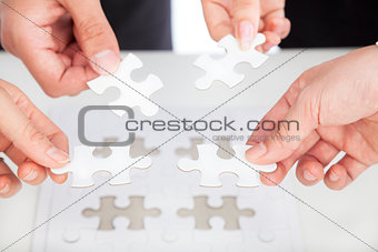Business team Holding Jigsaw Puzzle on the desk