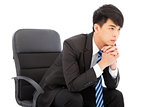 Young businessman thinking and sitting in a chair