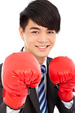 smiling young businessman with boxing gloves