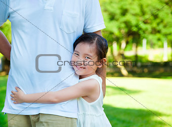 pretty little girl hug father waist in the park