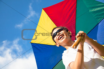 happy little boy hold a colorful umbrella with blue sky 