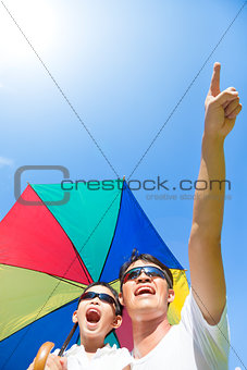 happy father and son holding a umbrella with blue sky