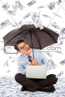 happy business man sitting on floor and holding a umbrella 