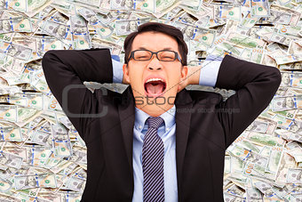 happy young business man lying on the us dollar
