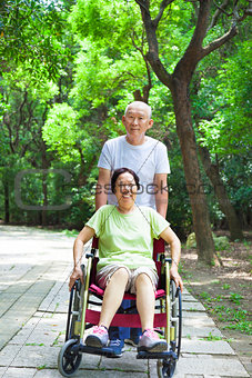  senior woman sitting on a wheelchair with his husband